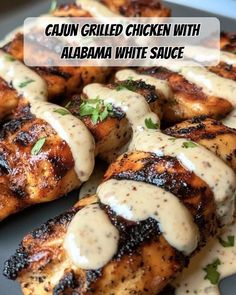 grilled chicken with white sauce is on a plate and has the words, cajun grilled chicken with alabama white sauce