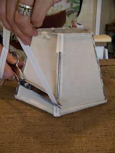 a person cutting fabric with scissors on top of a table