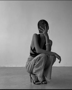 black and white photograph of a woman sitting on the floor with her hand to her face