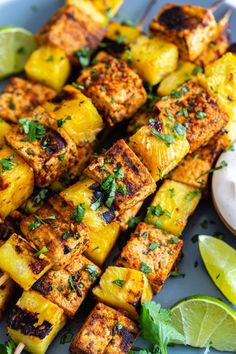 grilled pineapple and chicken skewers on a plate with lime wedges