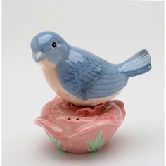 a blue bird sitting on top of a pink flower