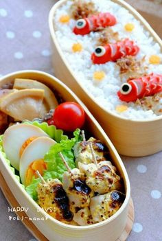 two wooden containers filled with food on top of a table