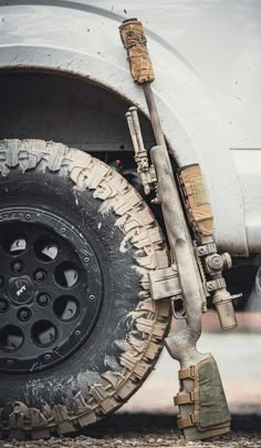 the front tire of a white truck with mud all over it's rims