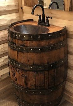 a wooden barrel sink sitting next to a mirror