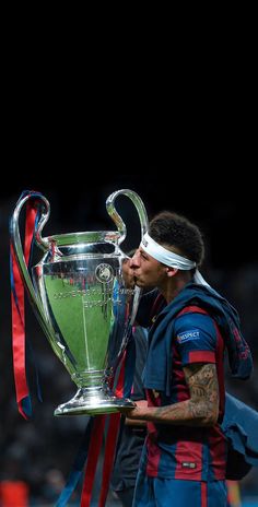 a soccer player kissing the trophy on his face