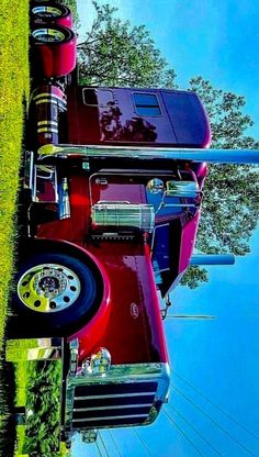 a red truck parked on top of a lush green field