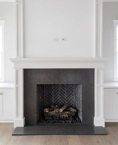 an empty room with a fireplace and white walls