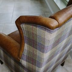 a brown leather chair sitting on top of a tiled floor