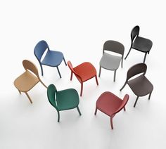 six different colored chairs in a circle on a white surface with one chair facing the camera