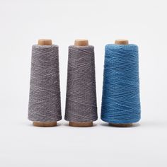 three spools of blue and grey yarn