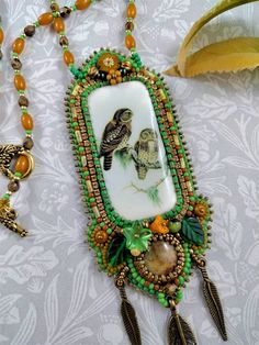 a necklace with an owl and bird on it