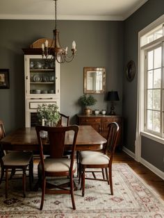 a dining room table with chairs and a rug on the floor