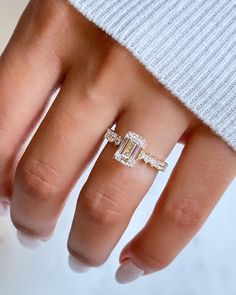 a woman's hand with an engagement ring on top of her finger and the other half of her wedding band