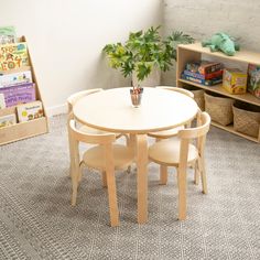 a child's table and chairs in a playroom with bookshelves behind them