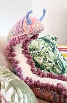 a close up of two pillows on top of a couch with decorative items around them