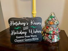 a sign that says hershey's kisses and holiday wishes next to a pile of candy