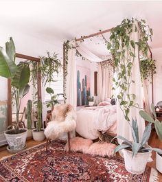 a bedroom with plants and rugs on the floor