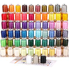 many spools of thread are arranged in rows on a white background with an assortment of colors