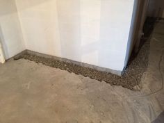 the corner of a room that is under construction with cement on the floor and walls