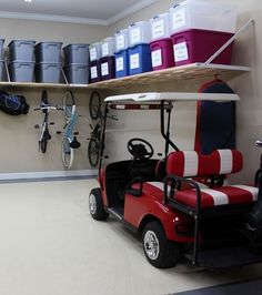 a golf cart is parked in the garage with several buckets on the shelves above it