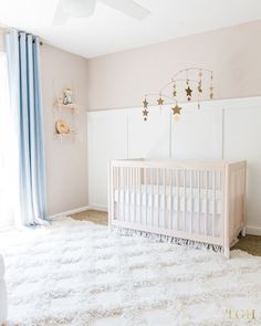 a baby's room with a white crib and blue curtains