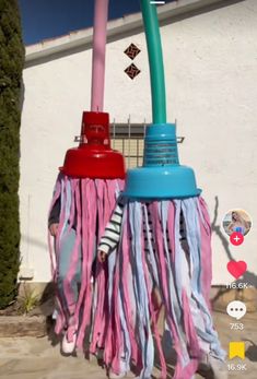 two pink and blue fire hydrants sitting next to each other in front of a building