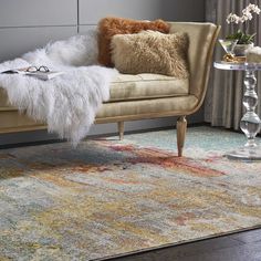 a living room area with a couch, chair and rug on the floor in front of a window