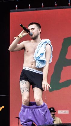 a man with no shirt on performing on stage