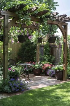 a garden with lots of flowers and plants on the side of the yard, along with a pergolated arbor