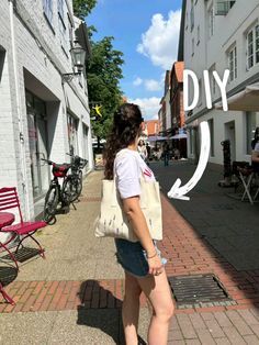 a woman is walking down the street with her back turned to the camera and there is a sign that says diy