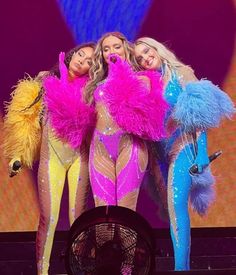 three women dressed in colorful costumes on stage