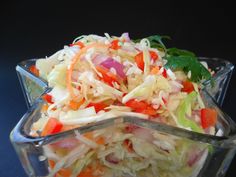 a salad with carrots, celery and onions in a glass bowl on a table