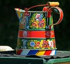 a colorful watering can sitting on top of a table