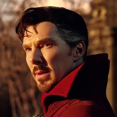 a close up of a person wearing a red coat and looking off into the distance