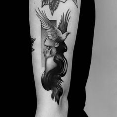 a woman's arm with a bird on it and an arrow in the middle