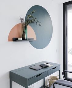 a desk with a plant on it in front of a wall mounted mirror and shelf