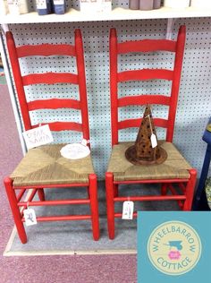 two red chairs sitting next to each other in front of a wall with signs on it