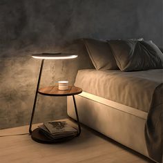 a lamp that is on top of a table next to a bed with pillows and blankets