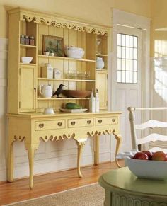 a yellow china cabinet sitting on top of a hard wood floor