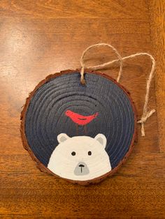 a wooden ornament with a polar bear on it's face hanging from a string