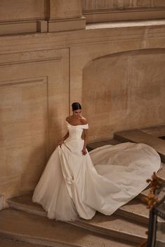 a woman in a white dress standing on some steps