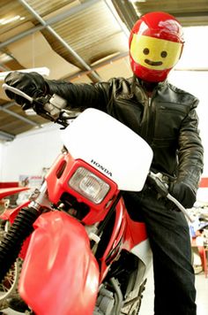 a man sitting on top of a red motorcycle