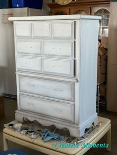 an old dresser is being painted white