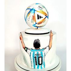 a cake with a soccer ball on top of it and the words messi written in blue