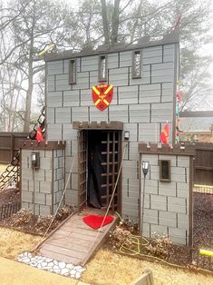 a small gray building with red flags on it's roof