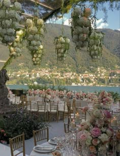 an outdoor dining area with tables and chairs set up for a formal function overlooking the water