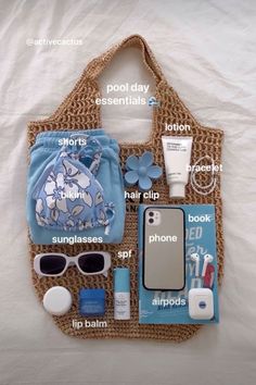 the contents of a purse laid out on top of a white sheet with blue flowers