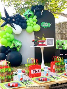 a table topped with lots of green and black bags next to balloons on top of tables