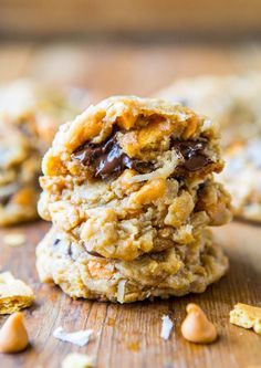 three cookies stacked on top of each other with chocolate chips and coconut flakes around them