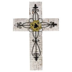 a cross with a flower on it is hanging from the side of a white wall